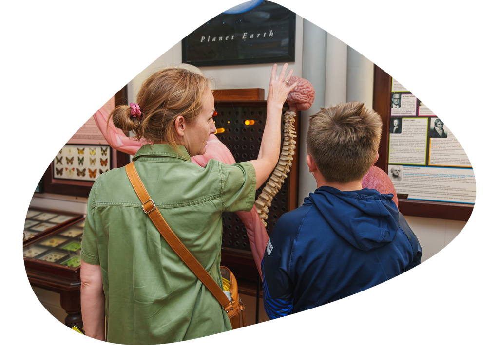 Teacher explaining to a student about the human body exhibit