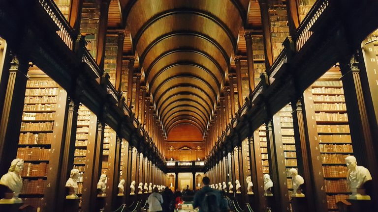 Blog 3 Historic Long Room at Trinity College Dublin library featuring a high wooden barrel-vaulted ceiling, dark oak bookshelves, and marble busts – featured Best museum in Dublin, Ireland